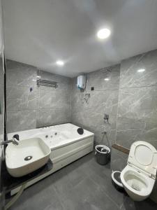 a bathroom with a bath tub and a toilet at Hotel hills in Ahmedabad