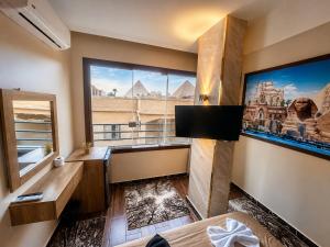 a room with a large window with a view of the pyramids at Master kings of the pyramids and Sphinx in Cairo +22 photos