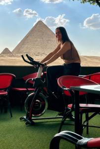a woman sitting on a scooter in front of the pyramids at Master kings of the pyramids and Sphinx in Cairo