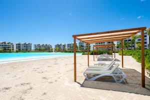 a row of lounge chairs on the beach at The Palms Boutique Hotel & Residence in Punta Cana