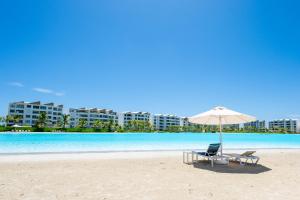 a beach with a chair and an umbrella on the beach at The Palms Boutique Hotel & Residence in Punta Cana