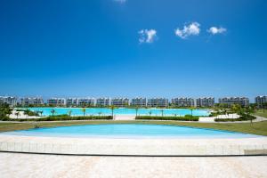 a large swimming pool with a large apartment complex in the background at The Palms Boutique Hotel & Residence in Punta Cana
