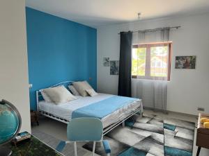 a bedroom with a bed and a blue wall at Casa verde in Tuzla