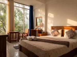a bedroom with a bed and a large window at Top Mountain Resort in Diyatalawa