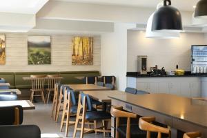 a restaurant with tables and chairs and a bar at Fairfield by Marriott Inn & Suites Grand Rapids Airport in Grand Rapids