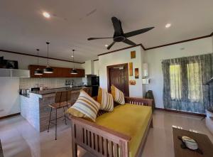 a living room with a couch and a ceiling fan at keio place in Thong Nai Pan Yai