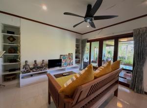 a living room with a couch and a ceiling fan at keio place in Thong Nai Pan Yai