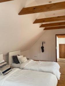two white beds in a bedroom with wooden ceilings at Prázdninový dům Litomyšl 79 in Litomyšl