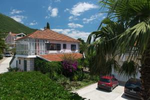 a house with a car parked in front of it at Apartments Batricevic in Herceg-Novi