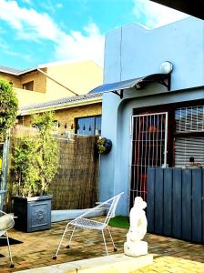 a white teddy bear sitting on a patio in front of a house at At Lilac Cottage, Jeffreys Bay Cozy stay for 2 & Business traveling in Jeffreys Bay