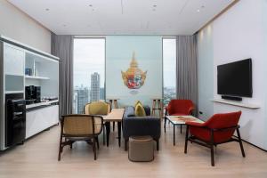a room with chairs and a table and a television at INNSiDE by Meliá Bangkok Sukhumvit in Bangkok