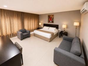 a hotel room with a bed and a couch at Hotel de Cuautla in Cuautla Morelos