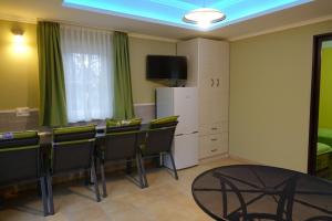 a room with a table and chairs and a television at Mesteri Apartman 1A-B in Mesteri