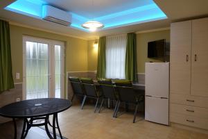 a dining room with a table and a refrigerator at Mesteri Apartman 1A-B in Mesteri