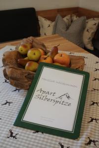 ツァムスにあるApart Silberspitzeのテーブルの上に置かれたフルーツバスケット(看板付)