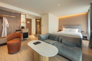 a hotel room with a bed and a couch at ROYS Hotel Bangkok in Bangkok +35 photos