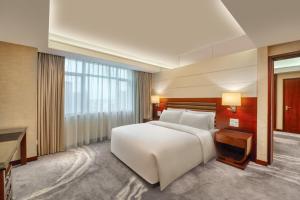 a bedroom with a large white bed and a desk at Crowne Plaza Foshan by IHG in Foshan