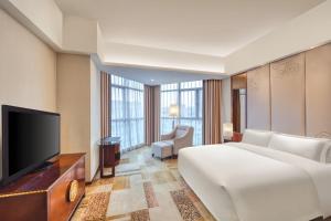 a hotel room with a bed and a flat screen tv at Crowne Plaza Foshan by IHG in Foshan
