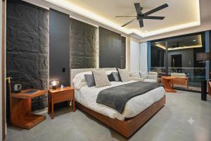 a bedroom with a large bed with a stone wall at Bahiban Residences Oceanfront by Monyxbnb in Cruz de Huanacaxtle +81 photos