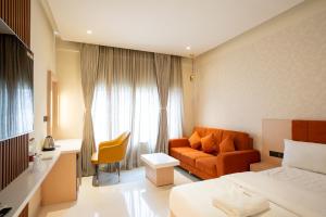 a hotel room with a bed and a couch at Freshup Hotel in Tirupati