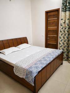 a bedroom with a bed with a wooden frame at Palam Villa in Kharar