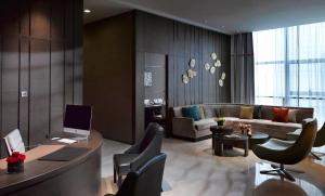 a living room with a couch and a table and chairs at Meliá Jinan in Jinan