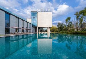 a swimming pool in front of a hotel at Meliá Chongqing in Chongqing