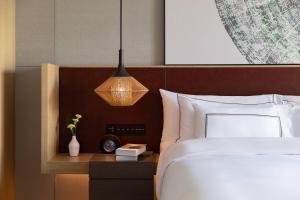 a bedroom with a bed and a pendant light at Meliá Chongqing in Chongqing