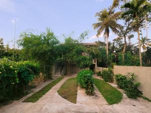 a garden with palm trees and a house at Lavera hideout in Dickwella