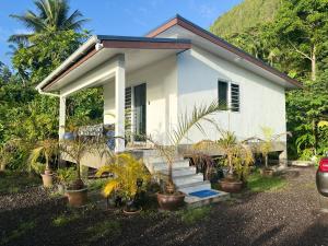 a small white house with plants in front of it at Vaihi's Garden climatisé, vue sur mer - Huahine in HUH