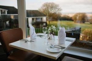 a table with glasses and napkins and a window at Bryn Meadows Golf, Hotel & Spa in Blackwood