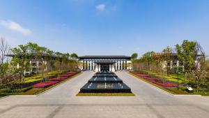 a garden with flowers and a pavilion in the distance at Gran Meliá Chengdu in Chengdu
