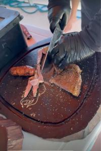 a person cutting a chocolate cake with a knife at Catamara Fenda do Biquini in Cabedelo