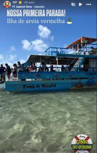 a blue boat on the beach with people on it at Catamara Fenda do Biquini in Cabedelo