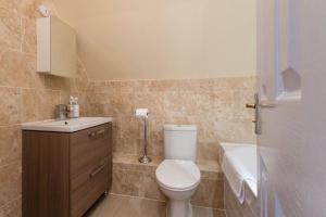a bathroom with a toilet and a sink and a tub at Luxury 3 Bed Home by the Lake in South Cerney +39 photos