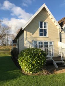 a house with a bush in front of it at Luxury 3 Bed Home by the Lake in South Cerney