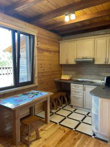 a kitchen with wooden cabinets and a table and a window at Cottages on Polyova in Zgorany