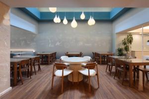 a restaurant with tables and chairs and a chalkboard wall at Meliá Lisboa Oriente in Lisbon