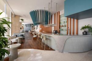 a restaurant with a bar with stools at Meliá Lisboa Oriente in Lisbon