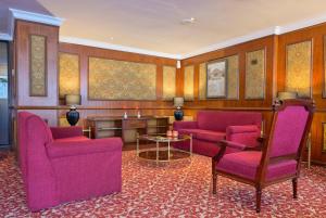 a living room with pink chairs and a table at Meliá Caracas in Caracas