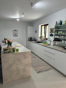 a kitchen with white cabinets and a counter top at Casa verde in Tuzla +13 photos
