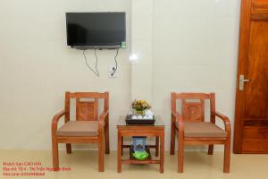 two chairs and a table with a tv on a wall at Khách Sạn Cao Hải in Cao Bằng