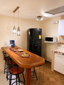 a kitchen with a wooden table and a black refrigerator at Apartment Angeluz in San Andrés