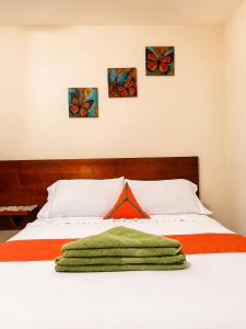 a bedroom with a bed with four paintings on the wall at Apartment Angeluz in San Andrés