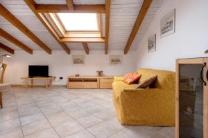 a living room with a couch and a television at Maison Adriano Lago Maggiore in Sangiano