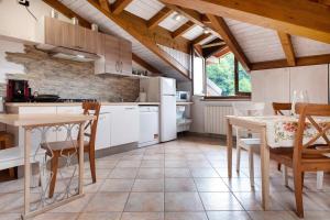 a kitchen with white appliances and a table and chairs at Maison Adriano Lago Maggiore in Sangiano