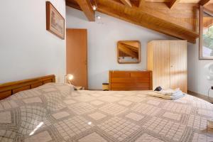 a bedroom with a large bed and a wooden ceiling at Maison Adriano Lago Maggiore in Sangiano