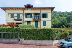 a house with a hedge in front of it at Maison Adriano Lago Maggiore in Sangiano