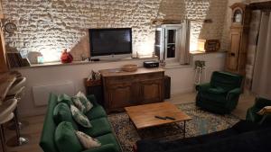 a living room with a couch and a tv at La grange d'Isabelle in Rouillac