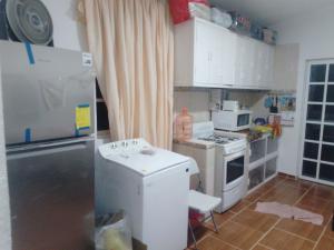 a small kitchen with a stove and a refrigerator at Oscar in Poza Rica de Hidalgo